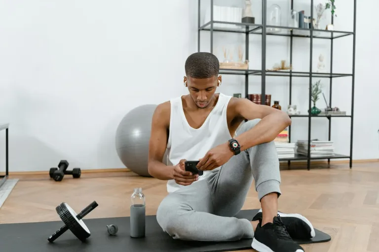 Online coach looking at a smartphone in a modern setting