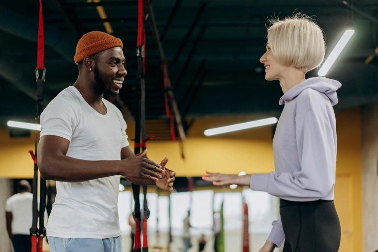 Personal trainer talking with a client in the gym